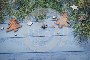 Christmas or New Year background: pine branches and some decorations for the Christmas tree on the blue boards