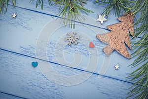 Christmas or New Year background: pine branches  wooden Christmas tree and some decorations on the blue boards