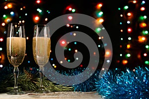 Christmas and New Year background. Romantic dinner of a couple in love with two glasses of champagne. Blue tinsel and spruce branc