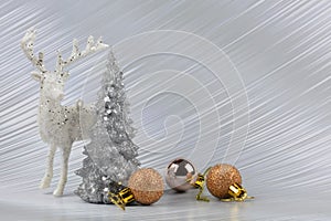 Christmas or New Year background with silver snowy tree and golden transitional decoration, deer