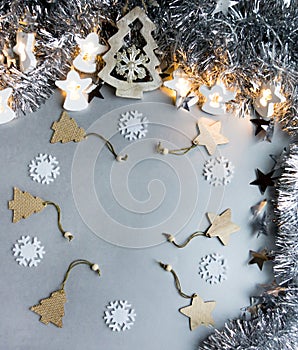 Christmas and New Year background. Snowflake, wooden Christmas trees, tinsel, stars and a luminous garland of angels on