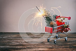 Christmas, new year background, supermarket trolley, fir branch, berries, red bag, sparklers