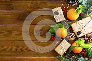 Christmas new year background with tangerines, gift boxes pine cones, winter decorations over wooden background with