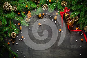 Christmas and New Year background. Christmas tree branch on a black background. Cones and fur-tree toys. View from above.