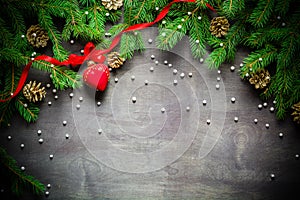 Christmas and New Year background. Christmas tree branch on a black background. Cones and fur-tree toys. View from above.