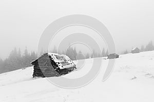 Christmas and New Year background with winter trees and cottage covered with fresh snow in the mountains - Magic holiday backgroun