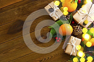 Christmas new year banner with tangerines, gift boxes pine cones, winter decorations over wooden background with copy space