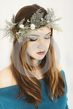 Christmas or New Year beauty woman portrait isolated on white background. Young woman with wearing a Christmas wreath on her head.