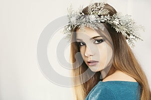 Christmas or New Year beauty woman portrait isolated on white background. Young woman with wearing a Christmas wreath on her head.