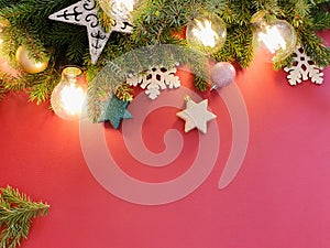 Christmas and new year border or frame. Fir tree, stars, balls and magic lights on red background. Top view, flatlay style. Free