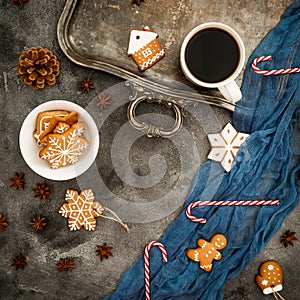 Christmas or New year breakfast. Frame of gingerbread, candy cane and coffee cup on dark table. Flat lay. Top view