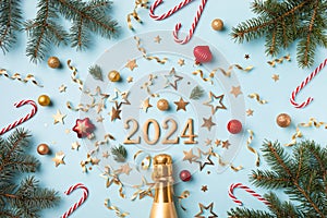 Christmas and New Year card with champagne bottle, 2024 numbers, fir tree, confetti stars and decorations top view. Flat lay style