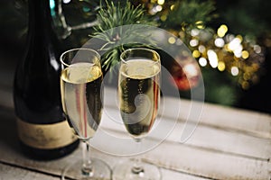 Christmas and New Year celebration with champagne. New Year holiday decorated tree, Two Champagne Glasses