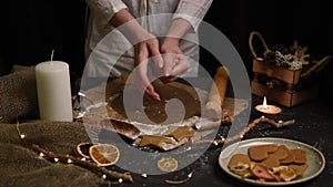 Christmas and new year celebration cooking table with prepairing gingerbread cookies, decor, candle, dry oranges, stars shape tool