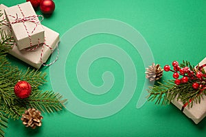 Christmas or New Year celebration green paper festive background with decoration fir tree, present boxes, cones, berries