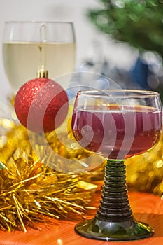 Christmas and New Year celebration holiday clock with two glasses of red and white wine and red ball covered with yellow fir on t