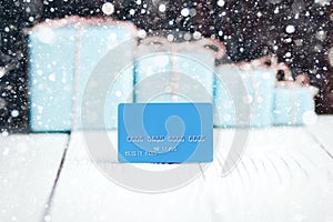 Christmas New Year composition blue credit card with gifts on ba