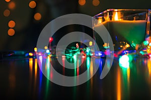 Christmas New Year Composition with candle, garlands, colorful lights, selective focus Black Background Holiday Decoration, copy