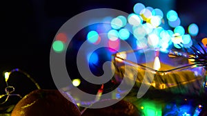 Christmas New Year Composition with candle, garlands, colorful lights, selective focus Black Background Holiday Decoration, copy