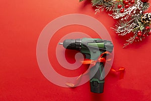 Christmas and new year composition with construction tools, screwdriver and Santa Claus hat on a red background. The concept of