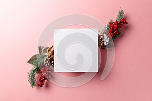 Christmas and new year composition. Creative layout made of paper blank on pink background. Fir tree branches, red berry and decor