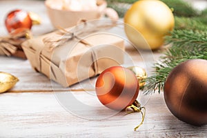 Christmas or New Year composition. Decorations, box, balls, fir and spruce branches, cup of coffee, on a white wooden background.