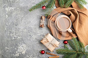 Christmas or New Year composition. Decorations, fir and spruce branches, cup of coffee, on a gray concrete background. Top view,