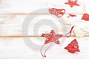 Christmas or New Year composition. Decorations, red stars, bells, on a white wooden background. Side view, copy space, selective
