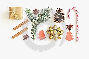 Christmas and New Year composition. Gift box with ribbon, fir branches, cones, star anise, cinnamon, candy cane and paper christma