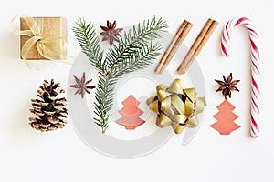 Christmas and New Year composition. Gift box with ribbon, fir branches, cones, star anise, cinnamon, candy cane and paper christma