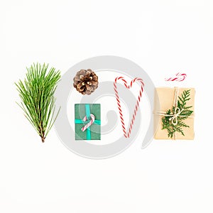 Christmas and New year composition of gifts with candy cane, pine branch and pine cone on white background. Flat lay. Top view