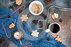 Christmas or New year composition. Gingerbread, candy cane and coffee cup on dark background. Flat lay. Top view