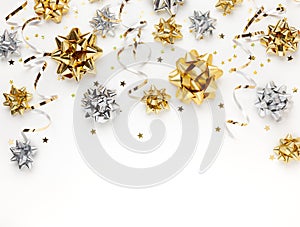 Christmas or New Year composition with gold and silver sparkling ribbon decorations on white background. Flat lay, copy space