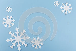 Christmas or New Year composition made of felt snowflakes on blue background. Winter season backdrop with decorative