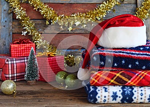 Christmas and New Year composition. Plaid, Santa Claus hat, gifts, xmas tree decorations on wooden background. Winter Holiday