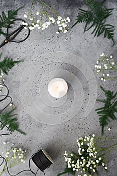 Christmas and New Year composition with single white candle on a table among winter decorations