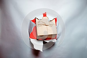 Christmas New Year concept, gift breaks through paper, with place for text