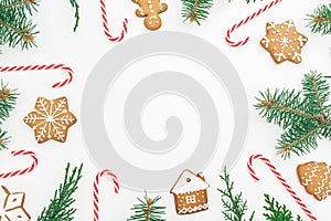 Christmas or New year concept. Round frame of gingerbread, winter tree and candy cane on white background. Flat lay. top view
