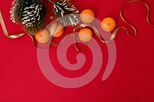 Christmas and New Year concept. Tangerines, a spruce branch and a golden festive chain. Space for text