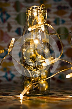 Christmas and new year decor with glass bottle and garland in vintage toning.