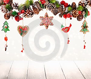 Christmas or New Year decor with hanging garland of fir branches, red berries, pine cones and other wooden ornaments. Winter