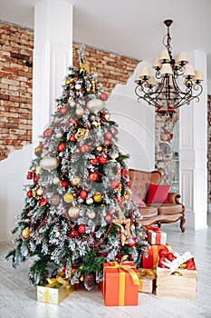 Christmas and New Year decorated interior room with red presents and New year tree and classic brown sofa in front of