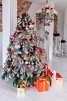 Christmas and New Year decorated interior room with red presents and New year tree in front of white wall.