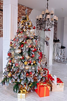 Christmas and New Year decorated interior room with red presents and New year tree in front of white wall.