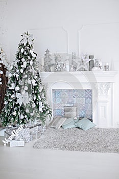 Christmas and New Year decorated white interior room with presents and New year tree and fireplace