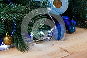 Christmas or New Year decoration background: fur-tree branches, colorful glass balls on wooden background. Christmas composition