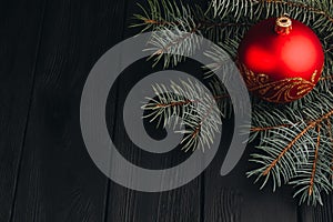 Christmas New Year decoration composition. Top view of fur-tree branches and balls frame on wooden background with place for your