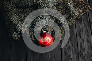 Christmas New Year decoration composition. Top view of fur-tree branches and balls frame on wooden background with place for your