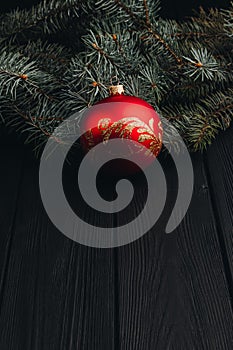 Christmas New Year decoration composition. Top view of fur-tree branches and balls frame on wooden background with place for your