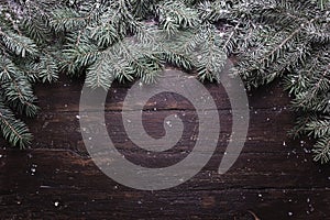 Christmas and New Year decoration composition. Top view of fur-tree branches on wooden background with place for your
